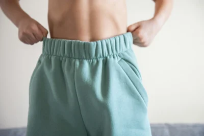 Toned stomach in sportswear, symbolizing successful fat loss through CLA and exercise.