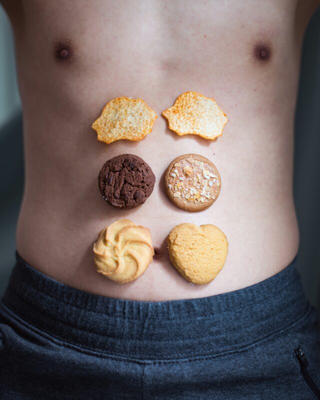 Cookies and chips arranged on a person’s belly